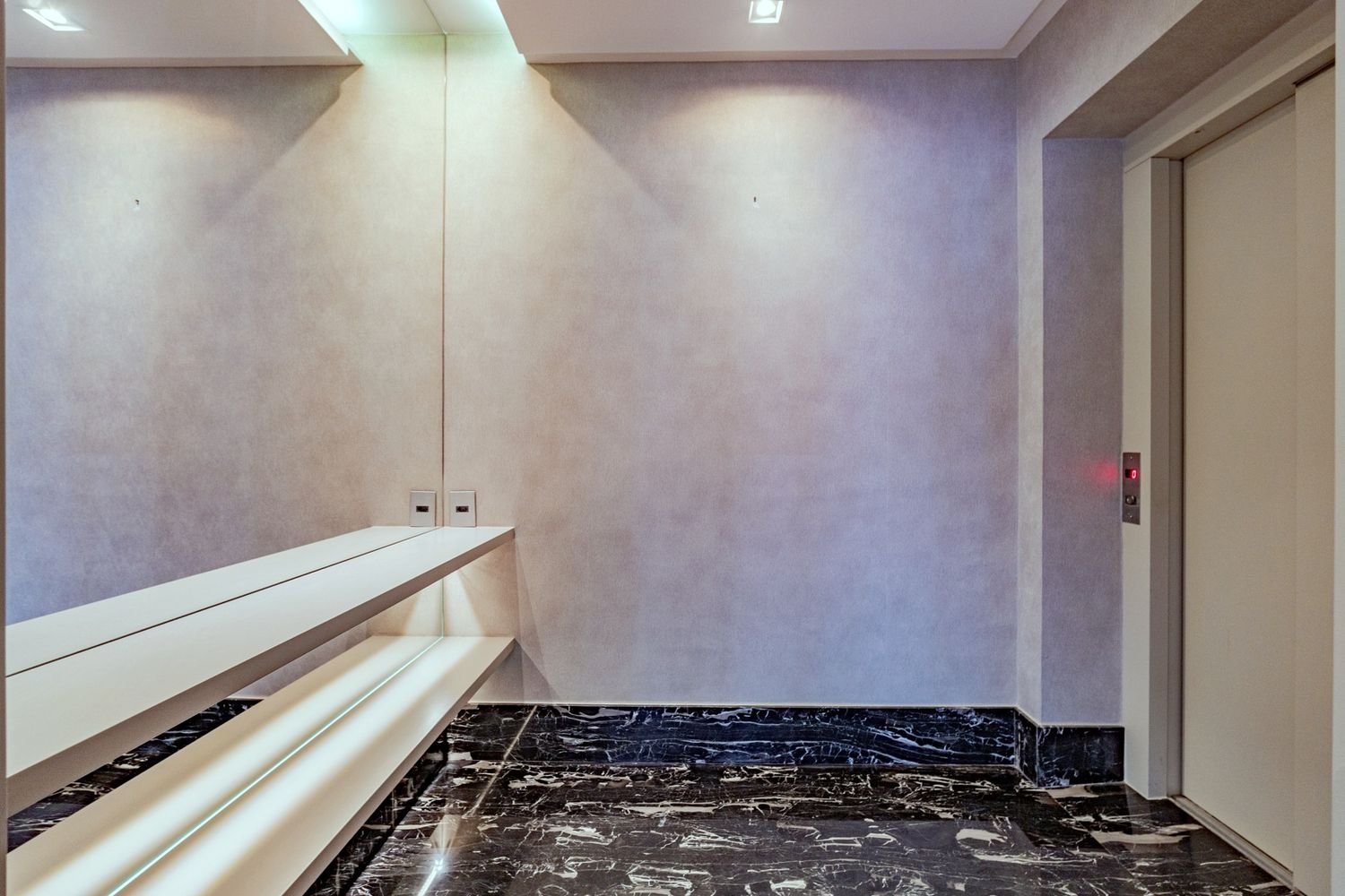 Hall privativo com piso escuro polido e bancada de apoio