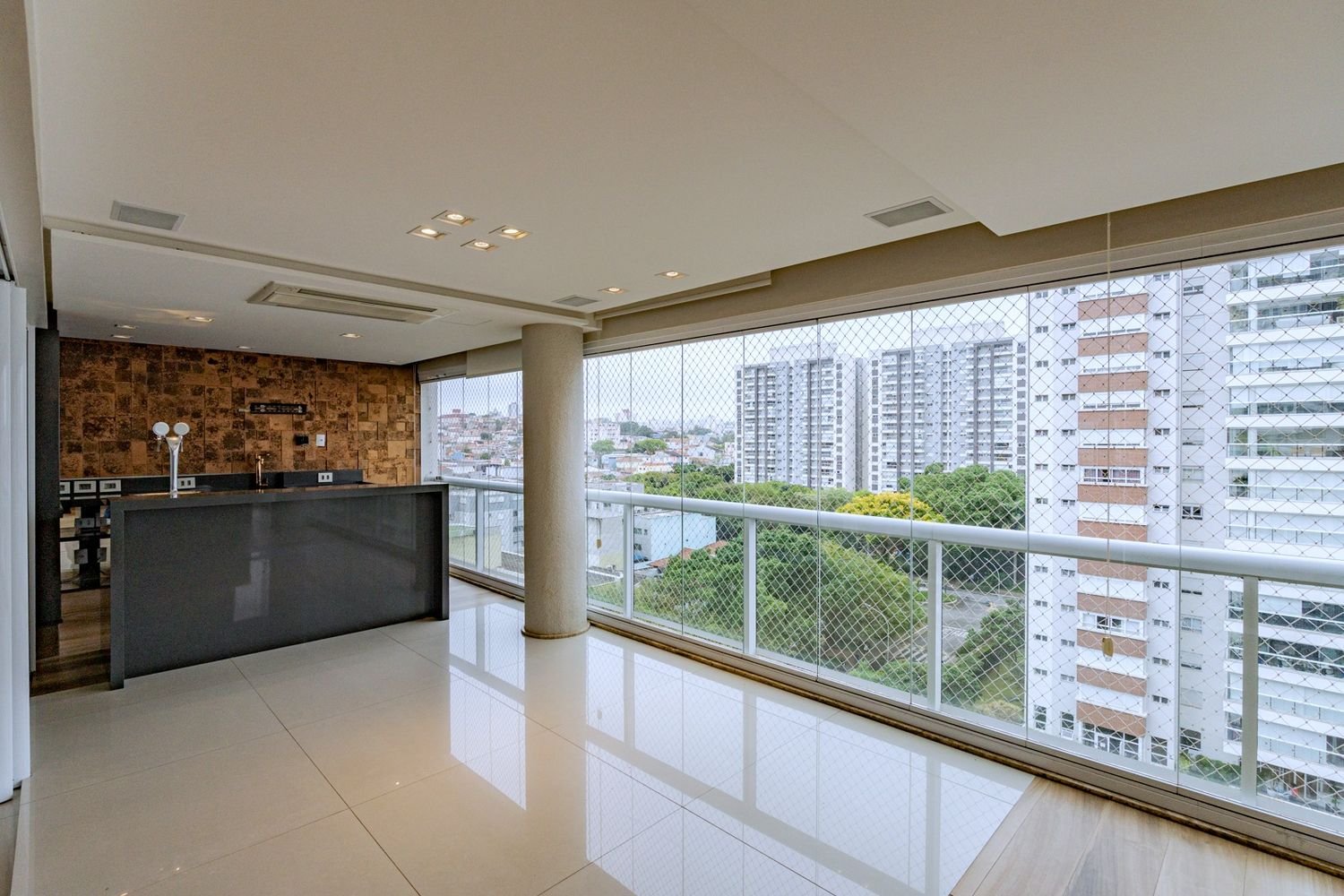 Varanda gourmet envidraçada com vista para o verde